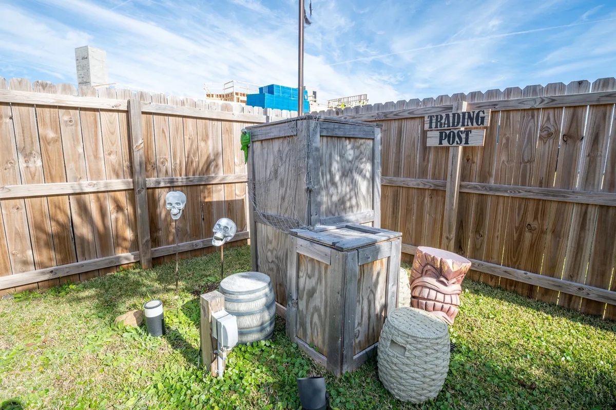 A quirky, themed outdoor trading post structure adorned with skulls, barrels, and a large sign. The adventurous decor offers a nod to pirate lore and provides a fun focal point for imaginative play, group photos, or themed activities.