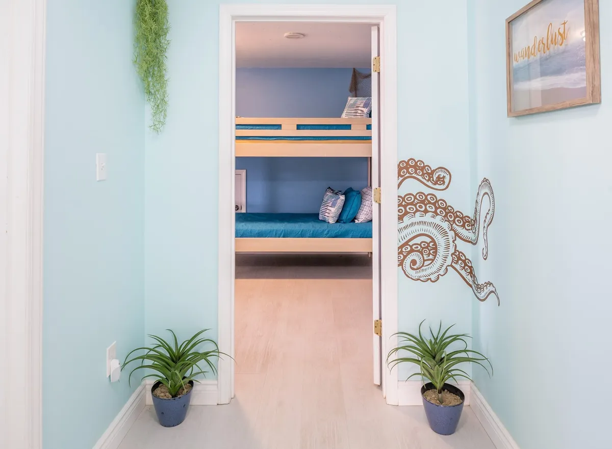 A playful kids' bunk room with an eye-catching octopus mural, decorative plants, and cozy bedding. The space is whimsical and themed for imaginative play and bedtime storytelling.